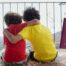 Dos niños de espaldas con un pasaporte italiano y el mapa de Italia, símbolo de la ciudadanía italiana por descendencia